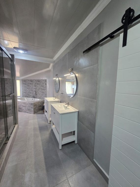 Main bathroom with a sliding barn door and twin vanities